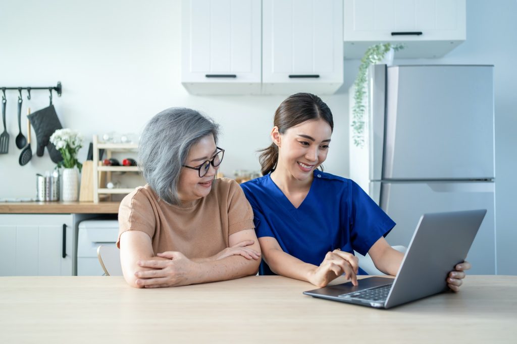 Asian nurse at nursing home take care of disabled senior elderly woman in house.